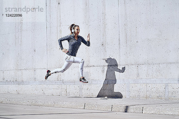 Female jogger with headphones on street