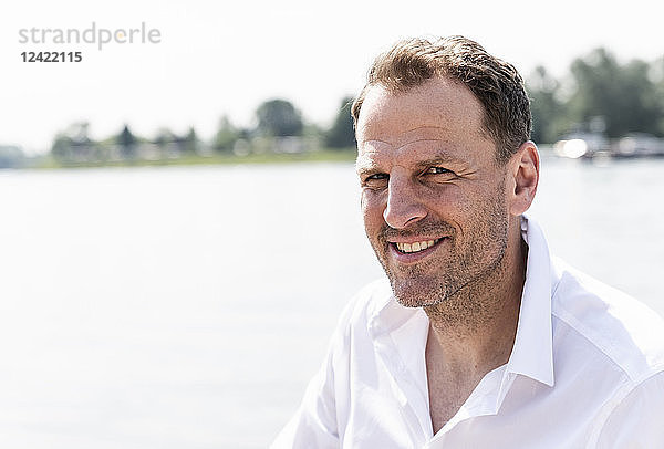 Portrait of smiling mature man at Rhine riverbank