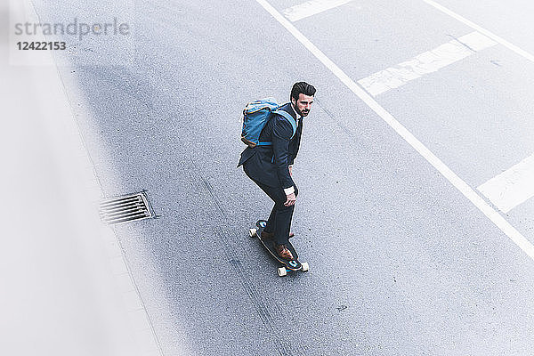Businessman riding skateboard on the street