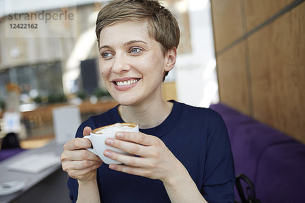 Portrait of blond businesswoman drinking coffee