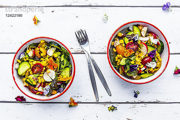 Two bowls of mixed salad with edible flowers