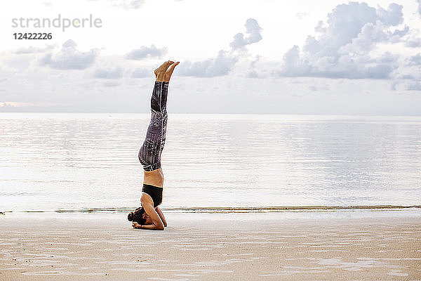Thailand  Koh Phangan  Sportive woman doing yoga on the beach