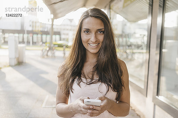 Pretty young woman using smartphone in the city