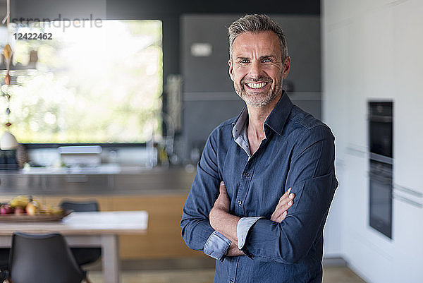 Portait of smiling mature man at home in kitchen