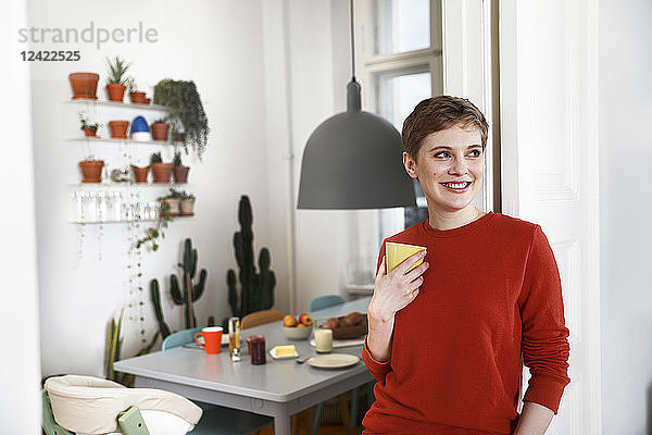 Woman standing in her comfortable home  drinking coffee