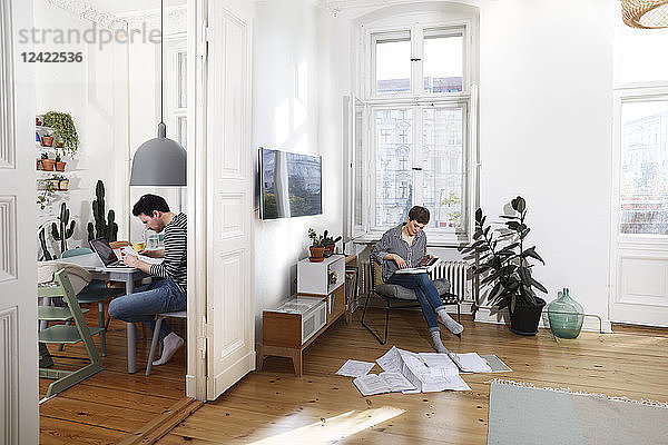 Couple sitting at home  sorting files with documents