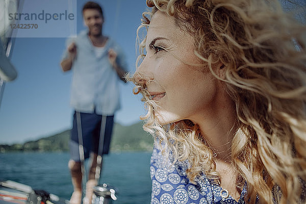 Smiling woman on a sailing boat with man in background