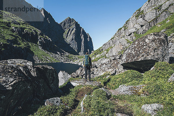 Norway  Lofoten  Moskenesoy  Young man standing in front of Litljordtinden