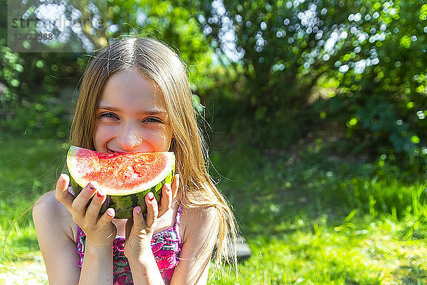Portrait of smiling girl eating watermelon in summer