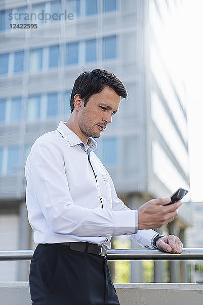 Businessman using cell phone in the city