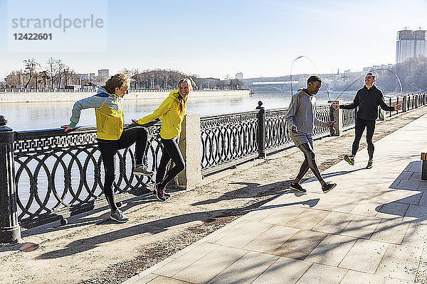 Friends exercising on waterfront promenade in the city