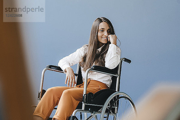 Young handicapped woman sitting in wheelchair  smiling