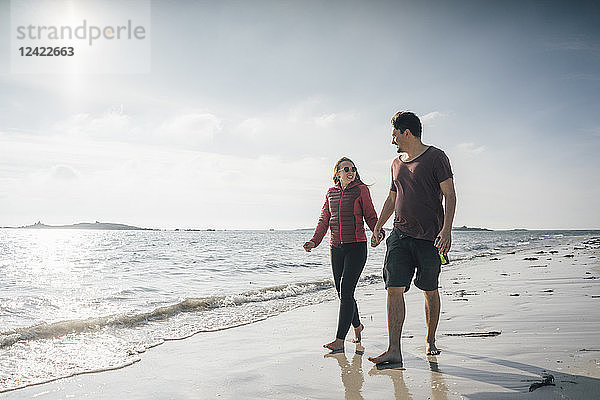 France  Brittany  Landeda  couple walking hand in hand on the beach