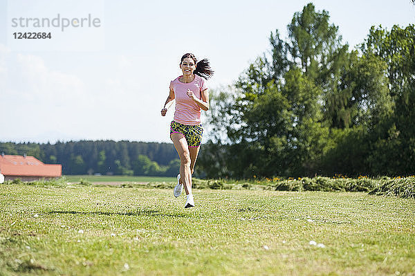 Young woman running on meadow