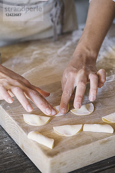 Woman preparing ravioli on pastry board
