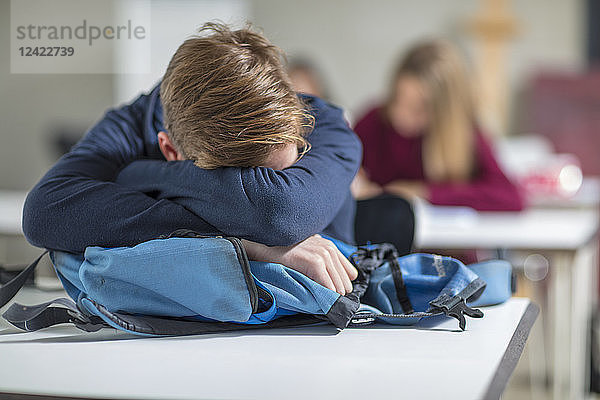 Teenage boy sleeping in class
