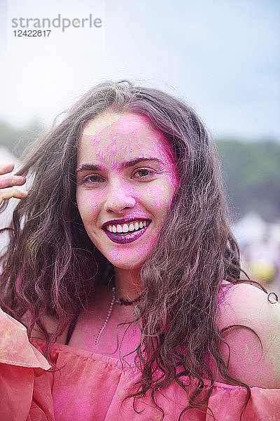 Portrait of young woman with colour powder at music festival