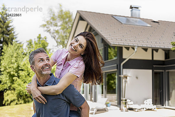 Portrait of happy couple in garden of their home