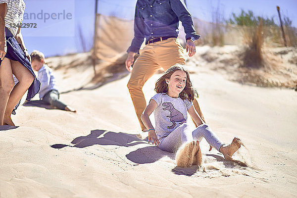 Happy girl with family having fun on the beach