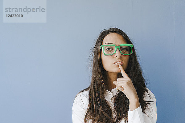 Young woman wearing pixel glasses  putting finger on mouth