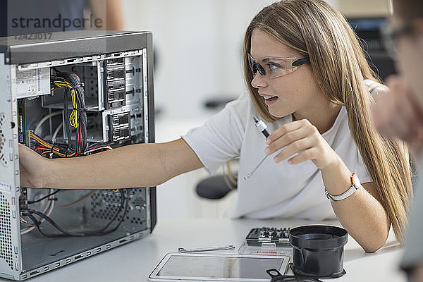 Students assembling computer in class