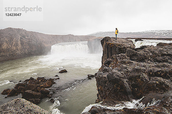 Iceland  woman standing at Godafoss waterfall
