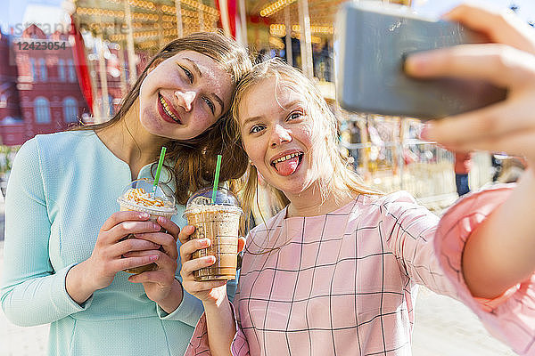 Russia  Moscow  teenage girls taking a selfie at funfair