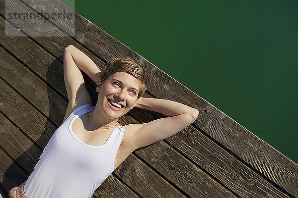 Portrait of smiling woman lying on jetty