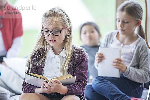 Schoolgirls reading books in school break room