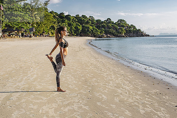 Thailand  Koh Phangan  Sportive woman doing workout on the beach