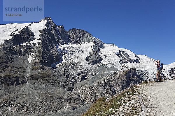 Austria  Carinthia  female hiker with binoculars watching Grossglockner peak  High Tauern National Park