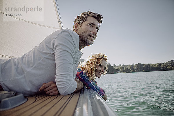 Smiling couple relaxing on a sailing boat