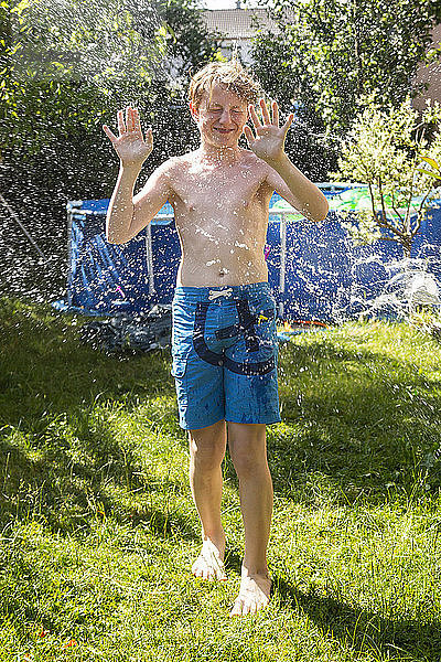 Boy in the garden splashed with water