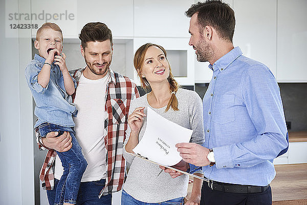 Family and real estate agent talking in new apartment
