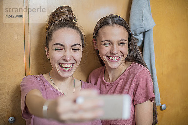 Portrait of two happy teenage girls taking a selfie