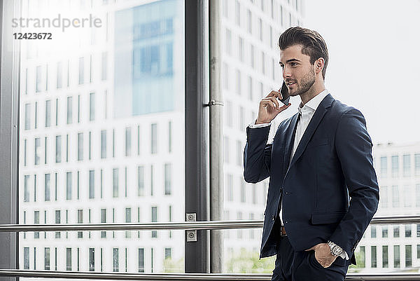 Businessman at the window on cell phone