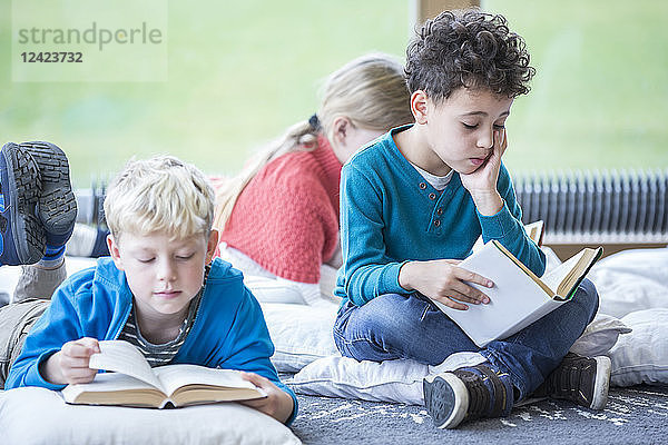 Pupils reading books on the floor in school break room