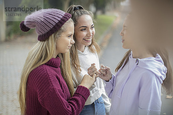 Smiling teenage girls making a pinky promise