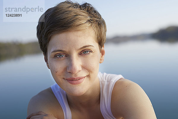 Portrait of smiling woman in front of lake