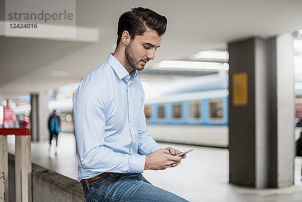 Businessman using cell phone at the station