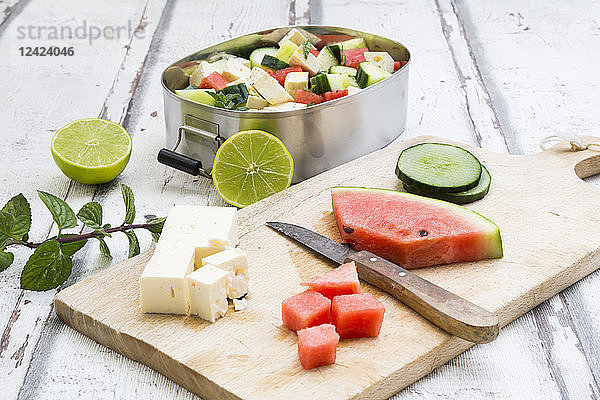 Lunch box  preparation of watermelon salad with feta  cucumber  ment and lime dressing