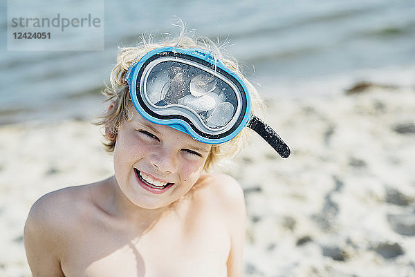 Portrait of happy boy wearing diving goggles on the beach