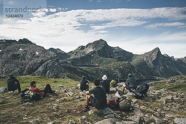 Norway  Lofoten  Moskenesoy  Young men taking a break  looking at the mountains