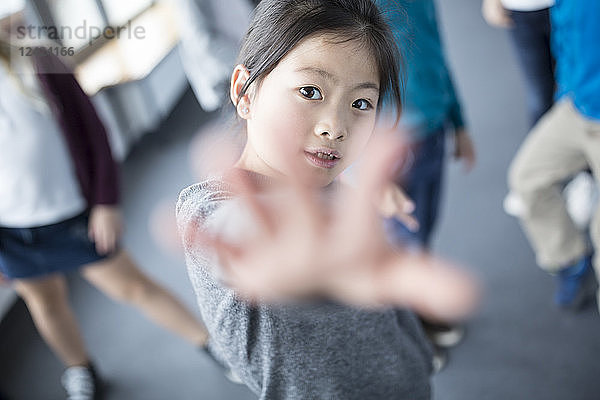 Portrait of schoolgirl raising her hand