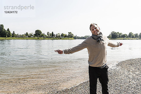 Happy mature man at Rhine riverbank