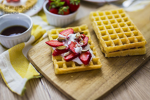 Waffle garnished with strawberries  Greek yogurt and almonds
