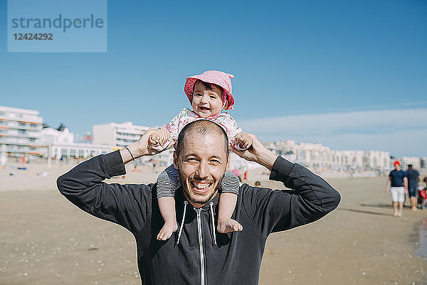 France  La Baule  portrait of father carrying his little daughter on shoulders on the beach