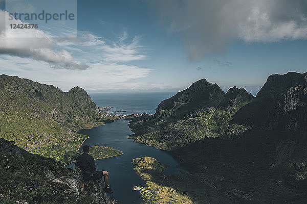 Norway   Lofoten  Traveller sitting on rock  looking over Agvatnet lake