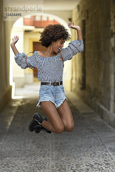 Laughing young woman jumping in the air