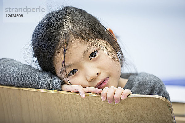 Portrait of schoolgirl on chair in school